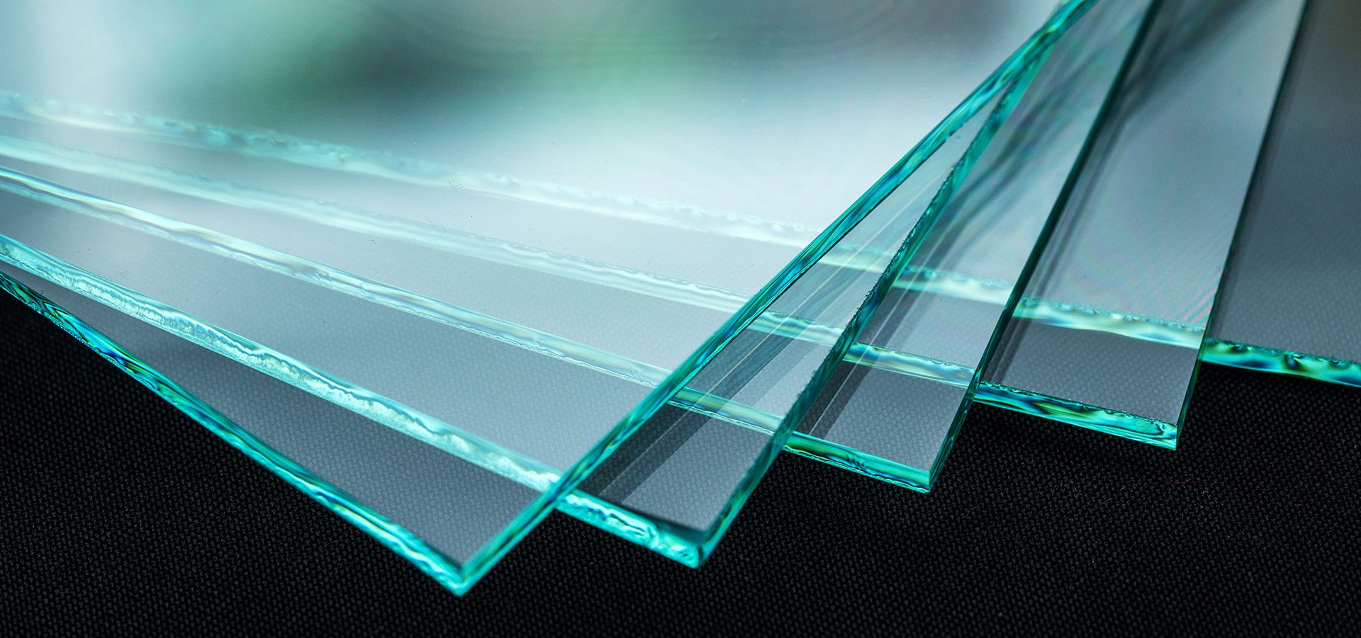 Aufeinanderliegende Glasplatten als Symbolbild für unsere Leistungen, darunter Spiegel nach Maß.